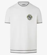Remera de algodón y poliéster color crudo, con cuello redondo y manga corta. Presenta textura acanalada horizontal, estampa localizada con escudo y ribetes en contraste en cuello y mangas.