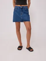 Minifalda de jean azul con bolsillos delanteros y traseros, tiro alto y corte recto.