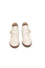 Bota corta color blanco hueso con textura de cocodrilo, taco de madera y hebilla dorada.