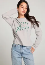 Camiseta gris de manga larga con cuello redondo y estampado frontal con la frase "J'ADORE Paris 72" en color verde.
