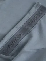 Chomba de piqué color celeste con cuello clásico y tapeta de dos botones. Presenta logo de la marca bordado en el pecho y cinta con el nombre de la marca repetido en las mangas.