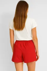 Short negro de lino y viscosa, con cintura elastizada y cordón ajustable. Presenta rayas verticales blancas en los laterales.