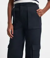 Pantalón recto de sarga color azul marino, con trabillas en la cintura, bolsillos cargo laterales y cierre delantero con botón y cremallera.