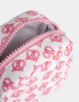 Monedero pequeño de tela deportiva color rosa con estampado de manzanas rojas. Tiene cierre circundante con tirador decorativo.