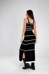 Vestido largo tejido a crochet, color negro con rayas horizontales blancas.
