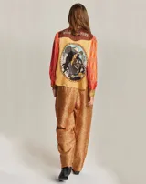 Pantalón recto con estampado geométrico en tonos marrón, naranja y blanco.