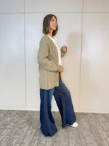 Saco tejido color camel, de corte largo y diseño de tejido abierto.