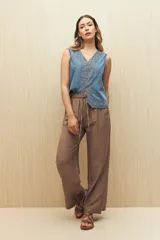 Pantalón palazzo color marrón con cintura elástica y lazo ajustable.