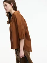 Camisa color crudo con botones en la parte delantera y mangas 3/4. Corte holgado.
