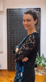 Vestido negro de manga larga, confeccionado en guipur bordado con flores azules y blancas.