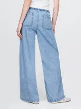 Pantalón de jean celeste claro, corte amplio, con cintura elástica ajustable con cordón, bolsillos laterales y traseros.