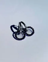 Par de aros colgantes con argollas doradas y dijes circulares de resina transparente con incrustaciones de strass de colores. El dije mide aproximadamente 1.5cm de diámetro.