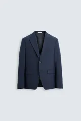 Blazer regular fit de hombre confeccionado en tejido con lana. Cuello con solapas de muesca, manga larga con puño abotonado, bolsillo de vivo en pecho, bolsillos de solapa en cadera, bolsillo interior, bajo con aberturas en espalda y cierre frontal de botonadura.