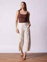 Pantalón crop de lino estampado con hojas en tonos verdes y azules. Tiene pretina trasera elastizada y bolsillos delanteros.
