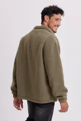 Campera de sherpa verde con cierre frontal y bolsillos laterales.