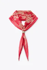 Pañuelo bandana de seda color rojo con estampado floral en dorado y cierre ajustable con pieza metálica y aplicación de piedra.