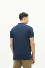 Polo color beige con textura, corte regular, logo estampado en el pecho y mangas cortas con ribete blanco.