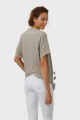 Remera color beige con estampado de flores marrones, corte recto y mangas cortas con detalle de doblez.