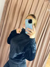 Conjunto deportivo negro de terciopelo, compuesto por un buzo de cuello alto con mangas largas y puños ajustados, y un pantalón jogger con cintura elástica.