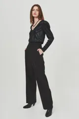 Pantalón negro de vestir, de corte palazzo y tiro alto, con bolsillos laterales.