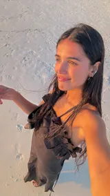 Vestido largo de lino color negro, con escote pronunciado en la espalda y detalle de volados en el escote delantero. Posee tiras finas para atar y ajustar, y tajos laterales.