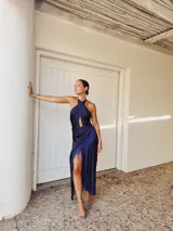 Vestido largo de seda lavada color azul marino, con escote halter cruzado, abertura en la falda y flecos en el ruedo.