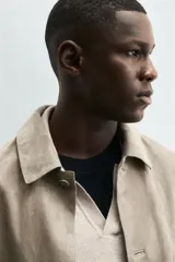 Cazadora de hombre de corte regular fit, confeccionada en piel con acabado ante color beige claro. Presenta cuello solapa, manga larga con puño de botón, bolsillos de plastrón en la cadera y cierre frontal con botonadura.