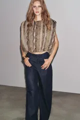 Pantalón de jean azul oscuro, de tiro alto, corte ancho y largo hasta el tobillo.