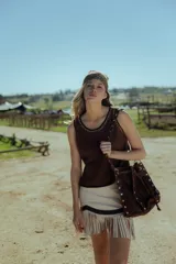 Minifalda marrón de cuero ovino con flecos y cierre frontal.