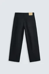 Pantalón de jean color crudo, corte amplio y tiro alto, con cinco bolsillos y cierre frontal con botones.