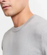 Sweater gris de tejido de punto con cuello redondo y mangas largas. Corte clásico.