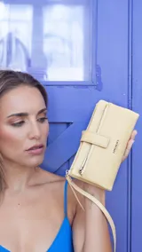 Billetera de mujer color beige, con presilla con broche, correa de mano, tarjeteros internos, monedero con cierre y bolsillo para billetes.