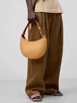 Bolso de hombro tipo baguette color crema, con textura granulada y asa corta regulable.