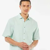 Camisa verde de manga corta con cuello clásico y cierre con botones.