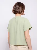 Camisa de manga corta color verde menta, con botones y escote en V, terminaciones onduladas.