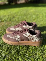 Zapatillas bajas color verde militar de gamuza con suela marrón y detalle trasero en color crema.