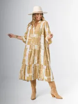 Vestido midi de corte amplio con estampado abstracto en tonos azules, blancos y beige. Tiene cuello en V, mangas 3/4 con volados y corte escalonado en la falda.