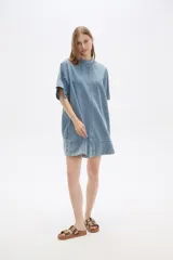 Vestido corto de jean celeste, de corte holgado, manga corta y cuello redondo.
