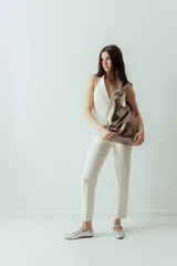 Maxi cartera tipo bolso de cuero natural, con base plana y diseño simple sin metales.