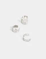 Set de tres aros earcuff plateados con diferentes diseños: uno liso con calados de corazones, uno con forma de cadena y otro con la palabra "Love" calada.