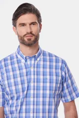 Camisa de manga corta con cuello abotonado y estampado a cuadros en tonos celeste, azul y blanco.