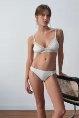 Conjunto de ropa interior color blanco, compuesto por un corpiño triangular con detalles de encaje y una bombacha clásica.