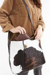 Bolso tipo tote de cuero marrón con textura de cocodrilo, doble asa corta y cierre superior.