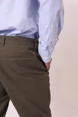 Pantalón chino color café con corte slim fit, bolsillos laterales y traseros.