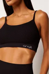 Top deportivo marrón con tecnología seamless, calce slim, breteles finos y textura con microtramas respirables. Cuenta con forro interno.