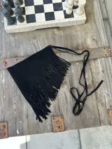 Faja negra con flecos largos de gamuza y tira fina para atar a la cintura.