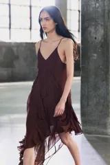 Vestido midi de viscosa color borgoña, con escote en V, tirantes finos ajustables, bordados a tono y volantes en el mismo tejido. El bajo es asimétrico.