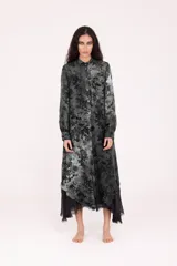 Túnica/camisa larga de manga larga con cuello camisero y botones frontales. Presenta un estampado floral en tonos de gris y negro, con una capa interna de tela negra que asoma en el ruedo irregular.