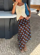 Pollera midi marrón con lunares celestes, de corte evasé y cintura alta.