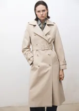 Trench beige de algodón con cuello de solapa, doble botonadura, cinturón con hebilla, trabillas en hombros y mangas largas con trabillas.
